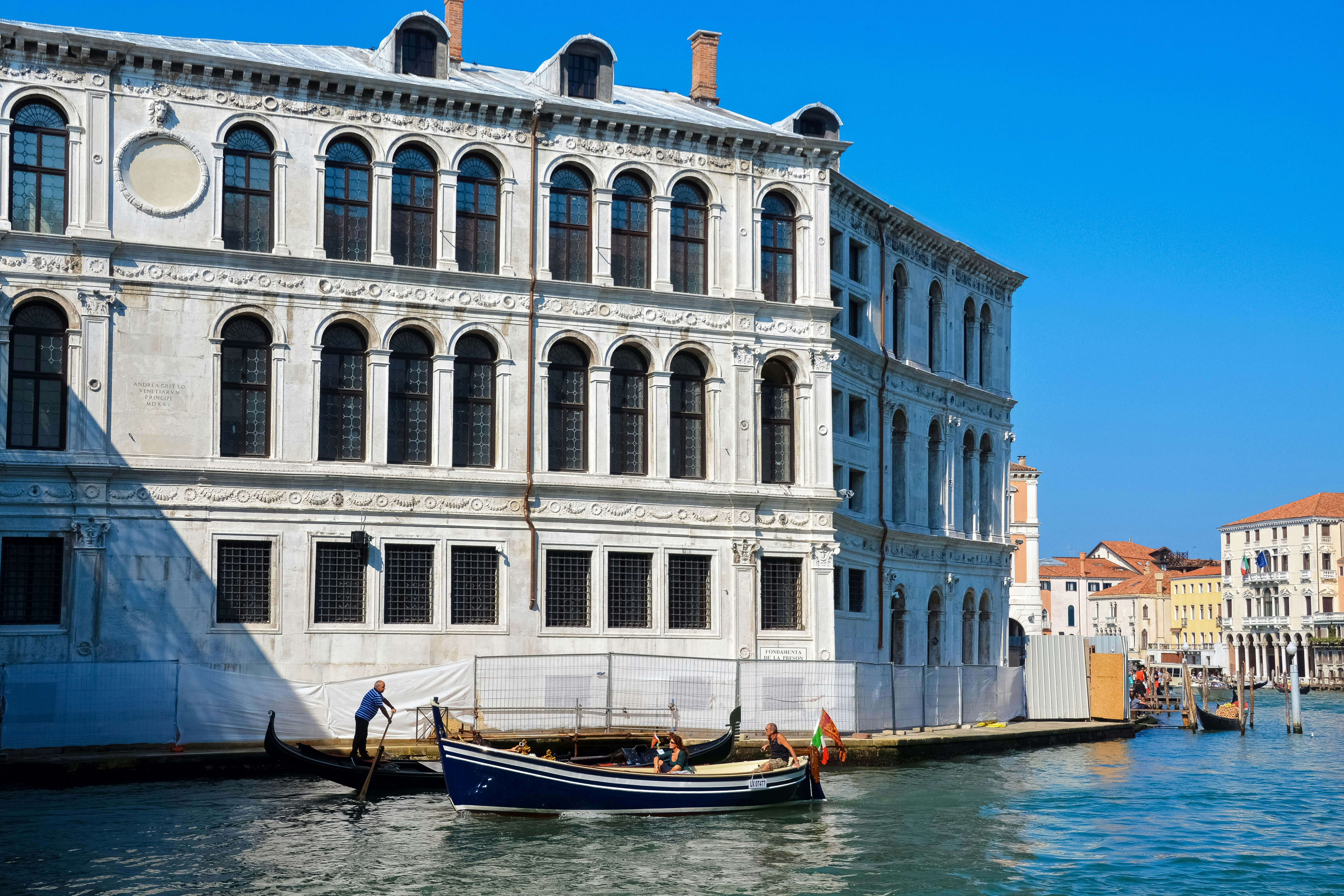 white and blue concrete building beside body of water during daytime